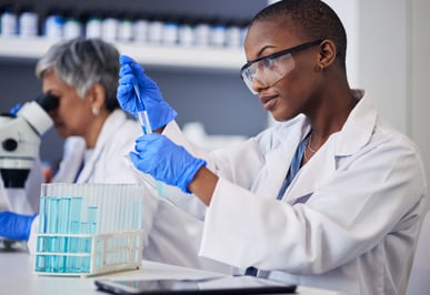 AdobeStock_671933899 Science, black woman and pipette with tube for test, research and investigation in laboratory. Female scientist working with dropper to study liquid sample, review solution and innovation of vaccine